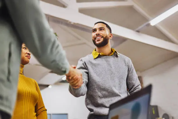Smiling man shaking hands with coworker